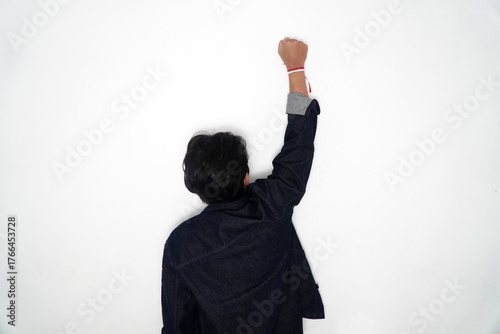Fotografie Raised fist with red and white ribbon (Indonesia flag colors) symbolizing spirit, struggle, and patriotism, against a bright white background with copy space
