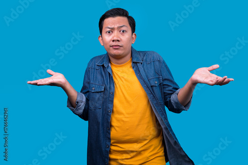 Bild auf Leinwand Asian Man Wearing Casual Clothes Shrugging Shoulders, Feeling Clueless And Confu