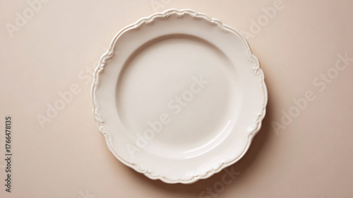 Elegant white plate with scalloped edge on a beige background.
