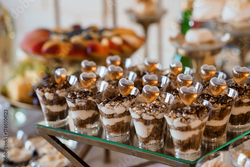 Elegant Wedding Dessert Display Featuring Chocolate Mousse Shooters with Heart-Shaped Garnishes on Silver Tiered Stand, Rich Brown and Gold Tones