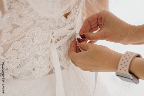 Photography Wedding Dress Corset Lacing Close-Up: Ivory Lace Bridal Gown Detail, Hands Adjusting Ribbon, Soft Focus, Romantic Ceremony Preparation