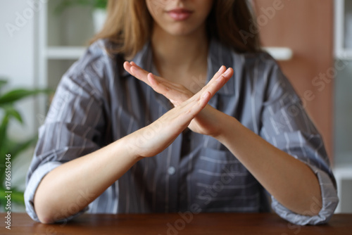 Fotografie Woman hands gesturing x or stop on a table