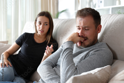 Sad man and woman counseling him at home