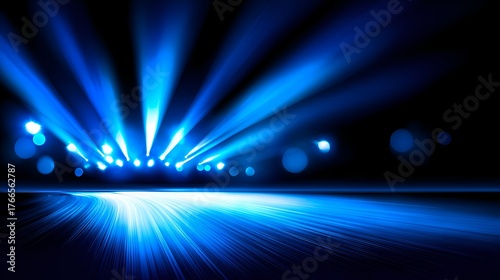 Dramatic blue light beams illuminate a dark stage, creating a vibrant atmosphere for an event