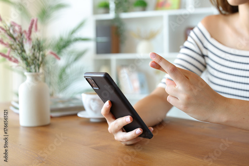 Hopeful woman hands holding mobile phone and crossing fingers