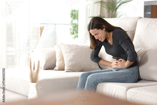 Stressed woman suffering belly ache at home