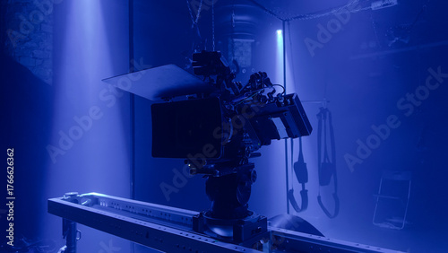 Professional film camera setup in a dark studio with dramatic blue light. Cinematic Sensual tension atmosphere capturing the creative process and visual storytelling of modern film production.
