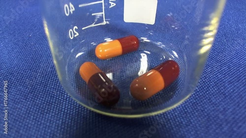 Pillole salvavita che cadono in un becher