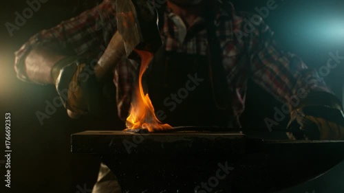 Close-up of blacksmith forging glowing hot iron on anvil with flying sparks. Super slow motion filmed on high-speed cinema camera at 1000 fps