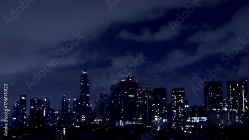 Time-lapse of the city lights shimmer through curtains of rain and flashes of thunder.