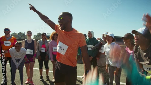A group of cheerful runners huddle, celebrating their shared passion for fitness and camaraderie. They raise their arms in excitement, ready for the challenge ahead.