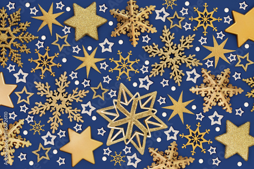 Xmas decorations gold star, snowflake, symbolic white snow flakes background on blue. Festive design for holiday Christmas season. Greeting card.
