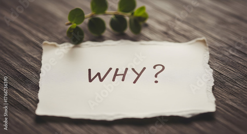 Paper note with the word why on a wooden surface for business problem solving concept