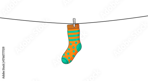 Single colorful sock with orange and green stripes and polka dots, hanging on clothesline with clothespin