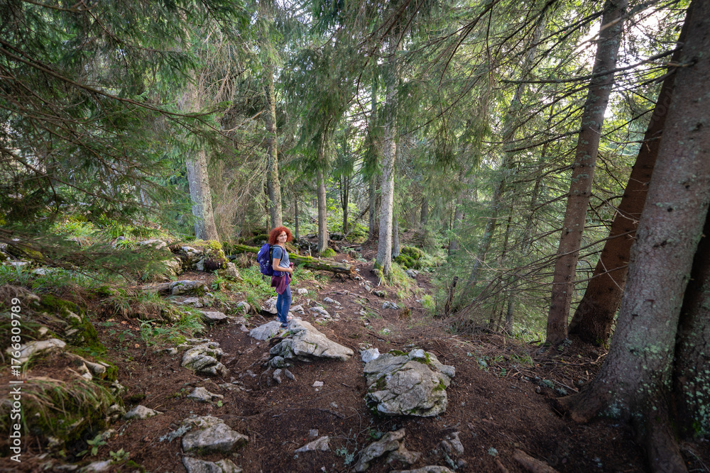Obraz premium Woman hiking on forest trail