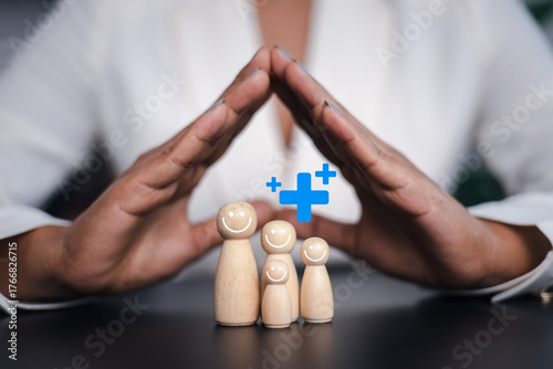 Bilde på lerret Family health insurance protection concept, hands protecting happy wooden family