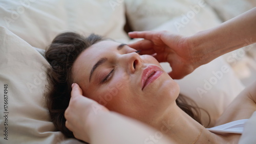Awake woman massaging temples at wakeup on bed closeup. Stressed lady migraine 
