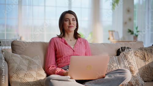 Distant manager browsing laptop developing project at home. Woman thinking work