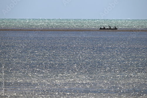 Native canoe just inside reef break.