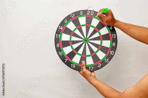 A person throwing a dart at a dartboard aiming for the number twenty, a game of skill and precision