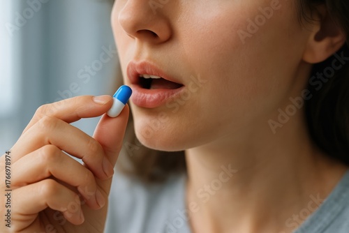Taking Medicine: Close-up of a woman's hand holding a pill, about to be taken to maintain health. A visual representation of health
