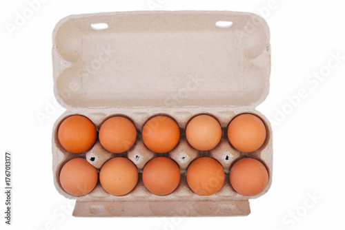 Top view of raw chicken eggs in egg box on on white background.