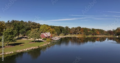 Aerial Drone View of Lake Ellyn Park in Glen Ellyn, Illinois with Red Boathouse and Fall Foliage Reflection
