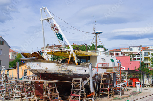 Dilapidated fishing boat undergoing repairs ashore