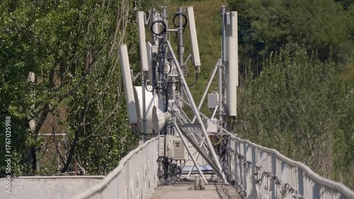 5G and 4G antennas and other telecommunication equipment is attached to the dam railings in the foothills of Himalayas. Shot in motion