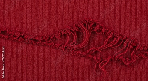 Close-up of torn red fabric with frayed edges
