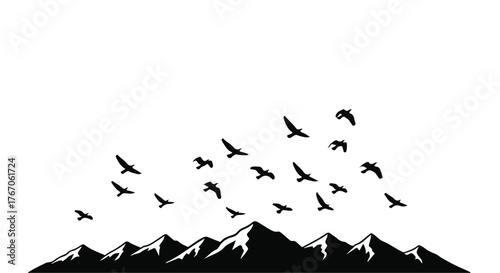 A flock of birds takes flight against a majestic mountain range under a clear sky.