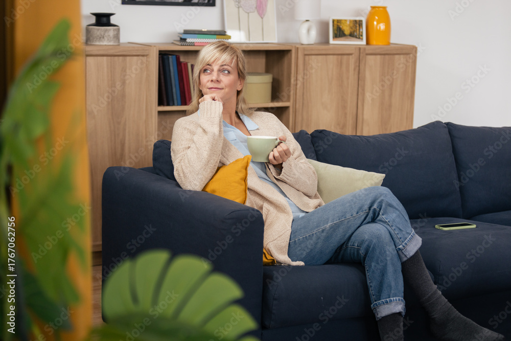 Obraz premium Mature woman relaxing at home enjoying coffee
