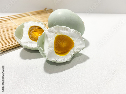 Salted egg isolated on white background. Half salted egg and whole preserved duck egg on white surface. Salted duck egg photography isolated on clean background. Boiled half and whole egg.