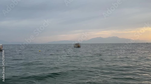Fishing boats sway on the waves in the Aegean Sea bay. Seaside vacation. Sea in Greece, Halkidiki. Relaxing, calming video.