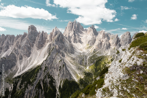 Daytime view of the silver Cadini di Misurina mountains on the Tre Cime trail, Dolomites, Italy. Summertime, greenery, blue skies.