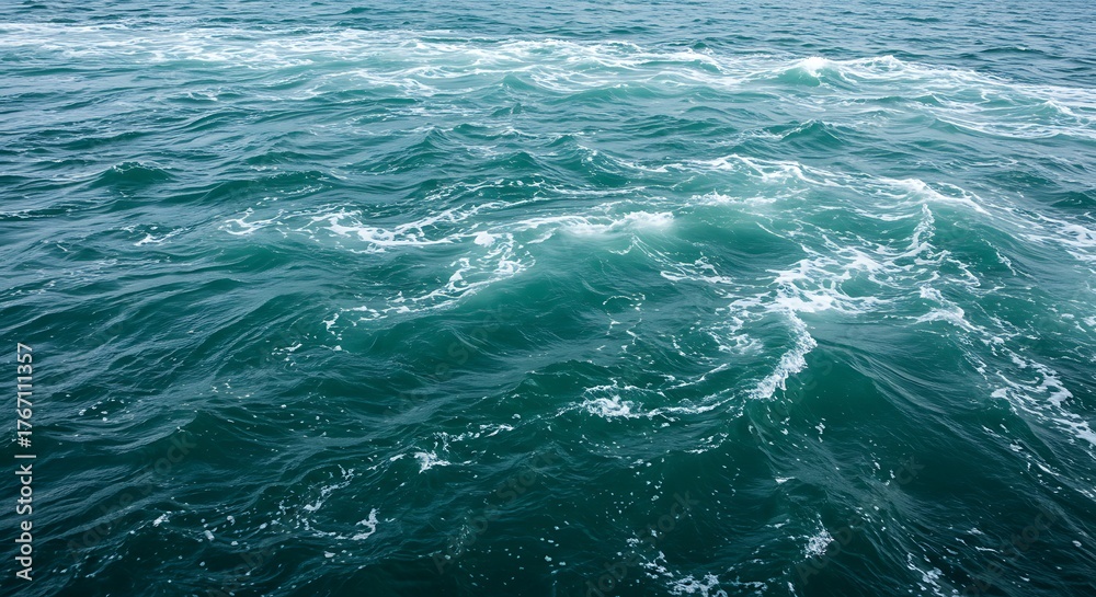 Fototapeta premium Serene ocean surface with rippling turquoise waves and white foam patterns