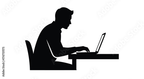 Silhouette of a man working on a laptop at a desk