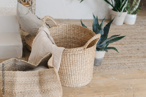 Handmade jute knitted baskets on a soft carpet near green indoor plants. Cozy home decor with natural materials, warm tones, and minimal boho style. Concept of comfort, sustainability, and slow living