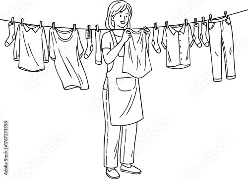 Woman hanging laundry on a clothesline in a domestic setting.