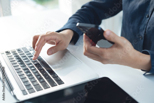 Canvas Print Business woman using smartphone and working on laptop computer with digital tablet on office table