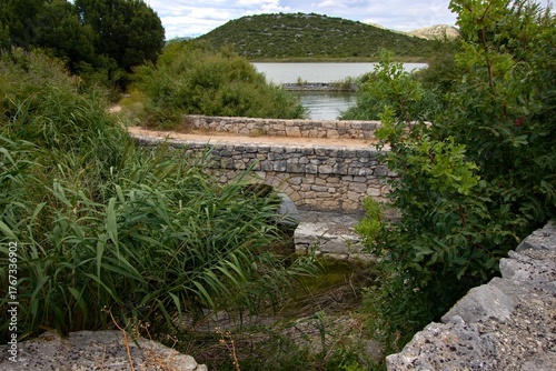 Old stone bridge in Vrana Lake (Vransko jezero) nature park wetland shore near Prosika (Pirovac), Zadar, Croatia