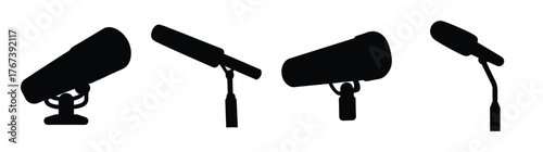 Collection of four black shotgun microphones displayed on stands in a row for audio recording and broadcasting