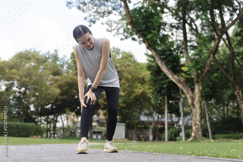 women holding her knee in pain during outdoor workout, indicating possible injury, joint inflammation, or muscle strain. Concept for sports injury, fitness discomfort and physical health issues.