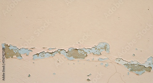 Peeling paint reveals older layers of blue and tan on a textured wall