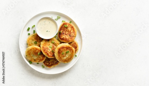 Potato pancakes made from mashed potato and green onion served with sauce