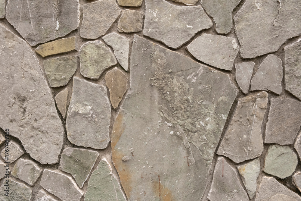 Obraz premium Stone wall made of various natural rock pieces in an outdoor setting