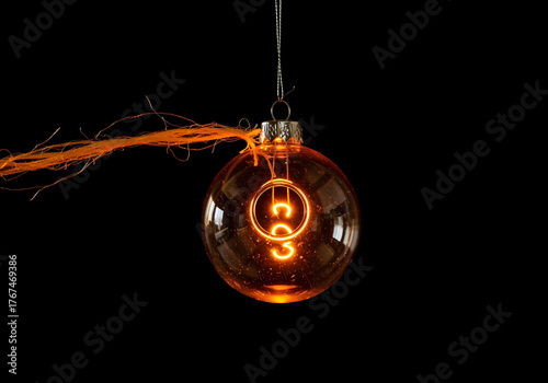 Transparent Ornament with Glowing Filament Inside on Black Background
