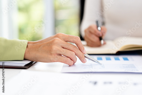 close up hands of Business partners working with analysis report and advisor showing plan, Two businesswoman working with Financial analysts reports and planning investment at office.