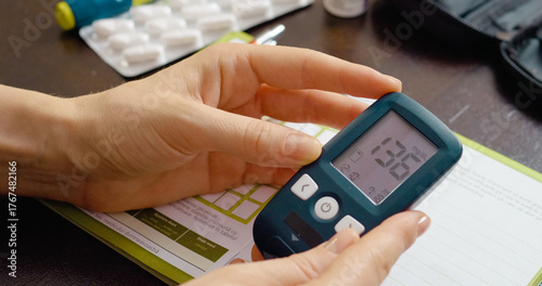 Behang A woman receives a high blood sugar reading on her glucometer at home