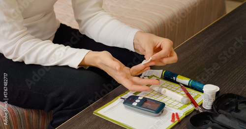 Tableau sur toile A woman uses a pen to prick her finger for a blood sugar test